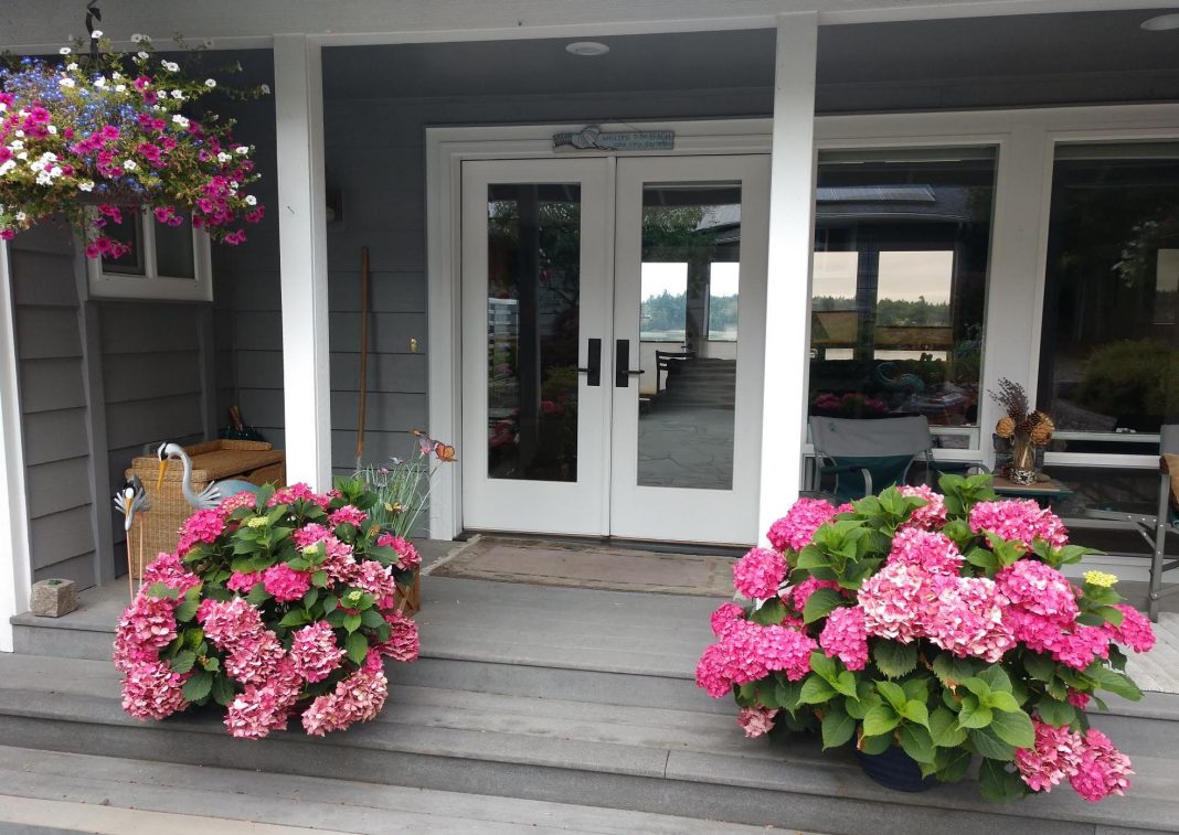 outside shot of a house with a porch and pink flowers
