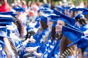 SPSCC college students sitting in caps and gowns at graduation 2022