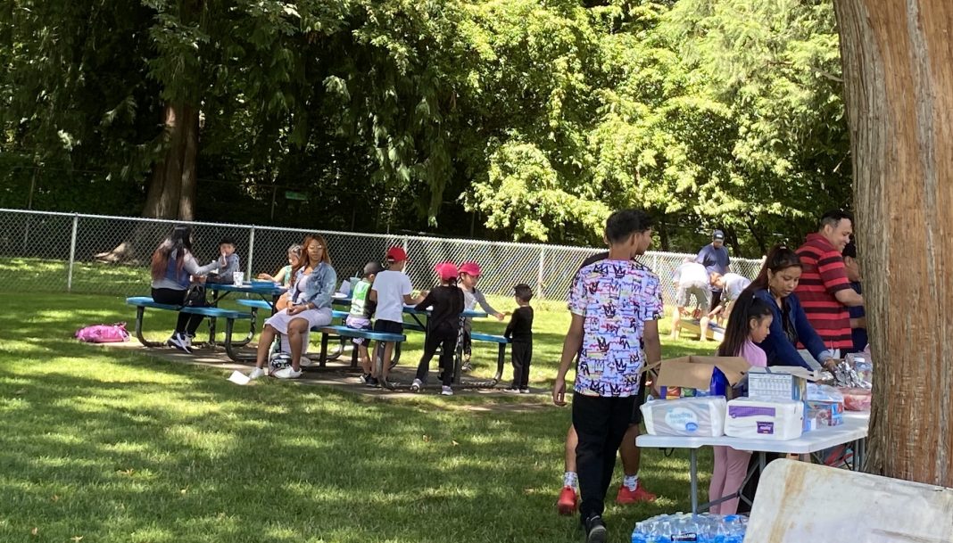 families hanging out at an event in a grass space with tables and chairs with Sound Parent to Parent