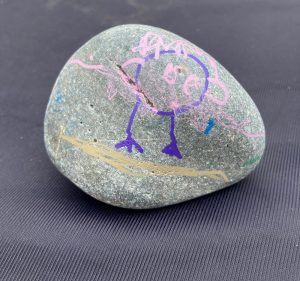 a rock with a kids drawing of an owl in a tu-tu