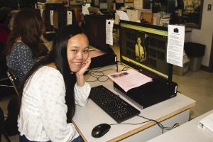 high school students sitting at desks with computers