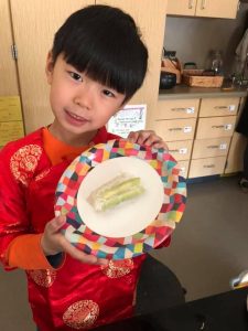 Brandon Pham holding up a plate with two spring rolls