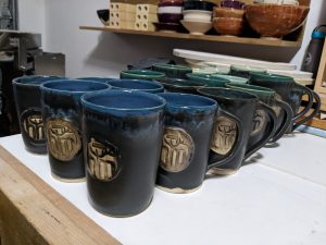 group of  blue-green Oktoberfest ceramic mugs on a white table