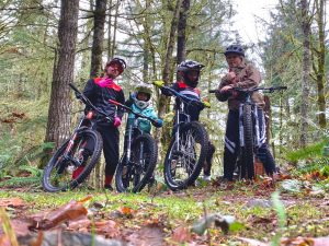 four people with their e-bikes in the woods