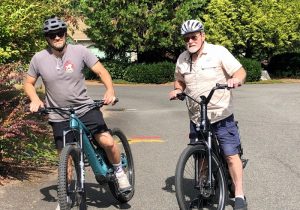 Matt Roder (left) and Mitch Roder (right) standing on their e-bikes