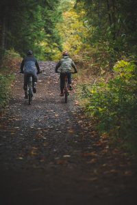 two people riding e-bikes on a Thurston County wooded trail