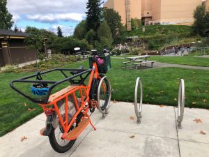 orange e-bike in a bike stand at Tumwater Falls. 