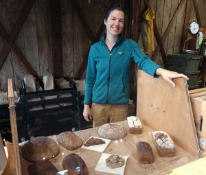 Kristen Jones standing by a table full of her bread at Olympia Farmers Market