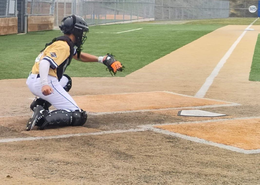 boy playing a catcher in a baseball game