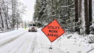 snowy road with a care and a caution sign