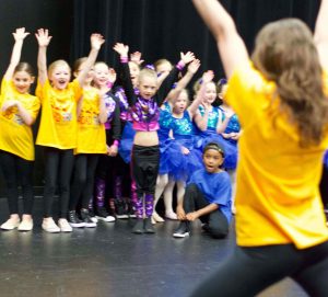 CEO and Artistic Director Hannah directing students on the stage before a recital