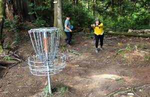 Ryan Harp and Mary-Charlotte Grayson playing on The Evergreen State College disc golf course in Olympia