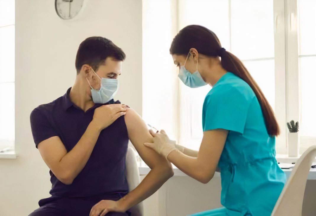 man getting a vaccine from a woman nurse