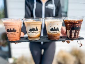 a woman holding a signature coffee flight at Northwest Grind 