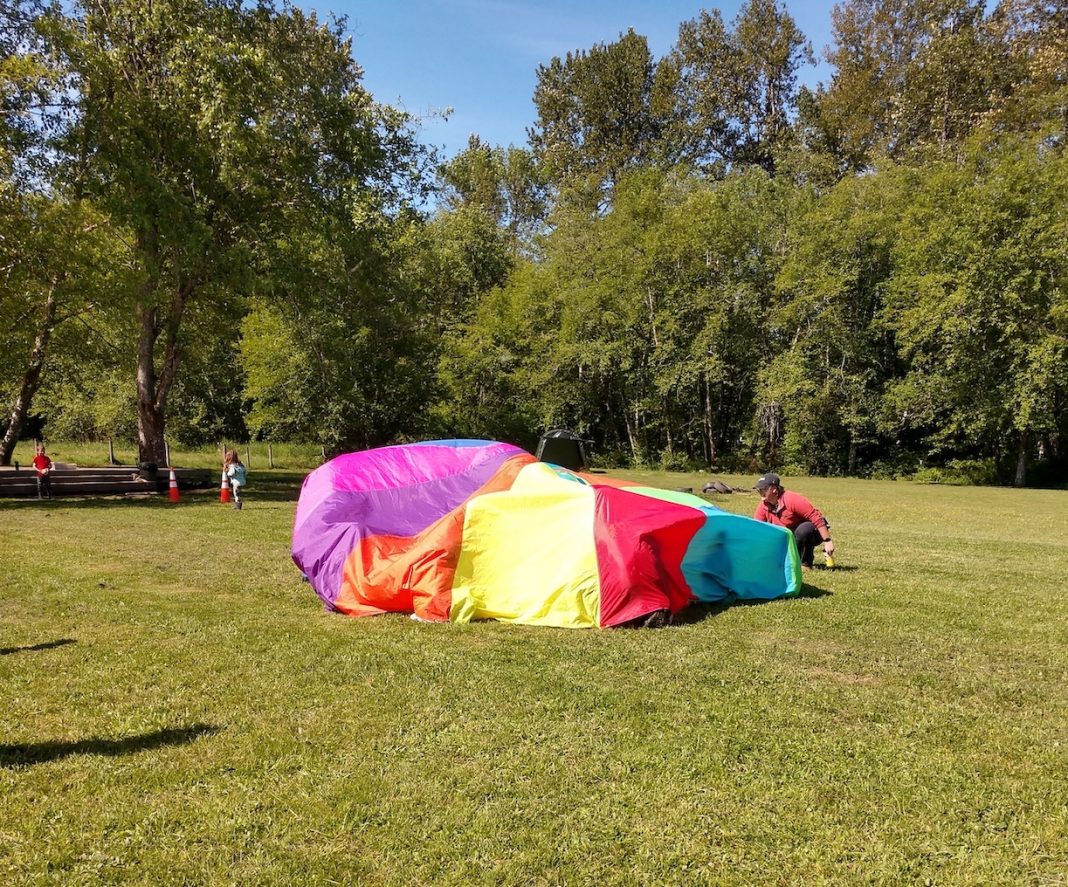 large field with a rainbow parachute game