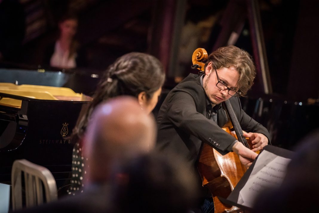 orchestra playing with a cello in player in focus