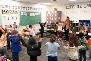 kids doing stretches in a circle in a classroom