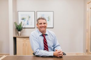 ason Andrew, financial advisor at OlyFed sitting at a desk