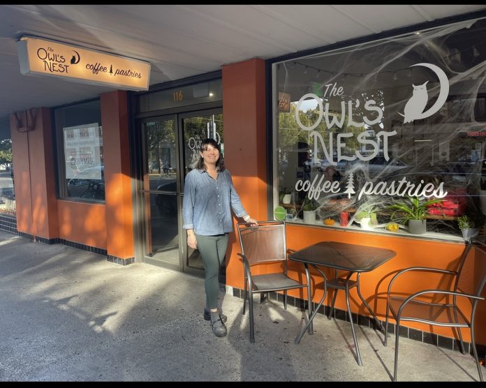 helby Haggard stands in front of The Owl's Nest coffee shop in Olympia