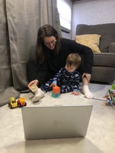 mother and child sitting on floor and looking at laptop
