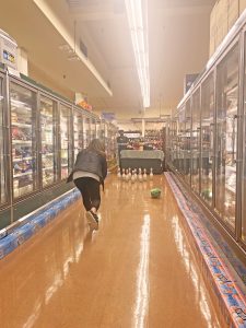 women bowling with a frozen turkey down Thriftway aisle