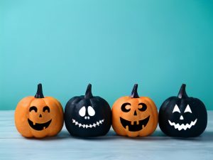 four alternating orange then black pumpkins with faces painted on them