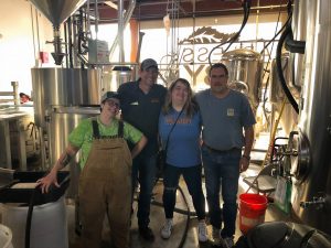 a group of people standing in a distillery 