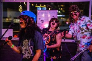 people doing karaoke in mullet wigs at Headless Mumby Brewery in Olympia