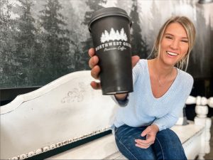 woman sitting on a bench holding a to go coffee cup at Northwest Grind Coffee in Olympia