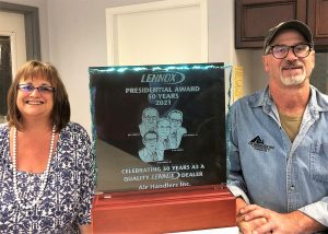 Mike and Donna Shattuck standing next to their Presidential Award for Air Handlers