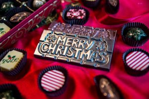 chocolate bar that says 'Merry Christmas' with truffles around it from Bittersweet Chocolate 