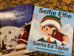 Two Christmas books on a table, 'The Night Before Christmas' and "Selfie Elfie'
