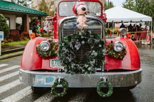 red vintage car with wreaths and a Christmas Snoopy on it at the Tumwater Tree Lighting Festival