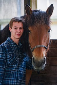 a person standing next to a horse