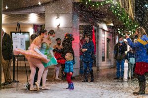 people playing in fake snow outside the Washington Center in Olympia
