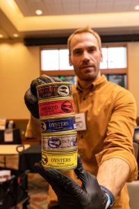 a man holding a stack of  Ekone Oysters containers