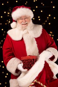 Santa posing for a photo with a starring background