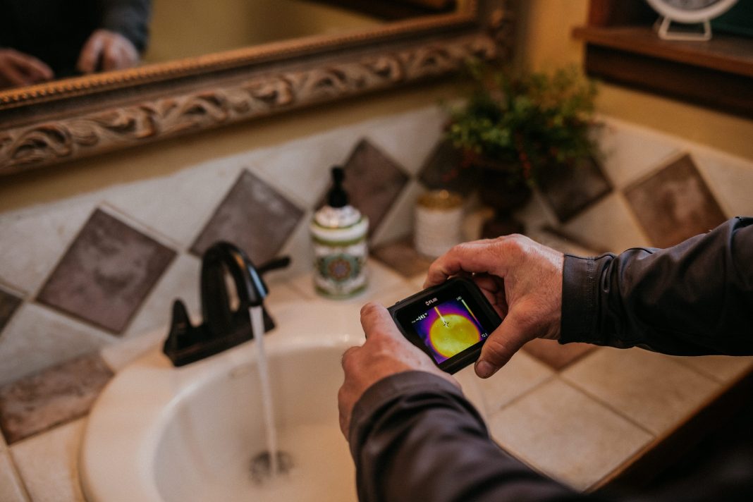 Boggs Inspection Services technician checking a bathroom faucet