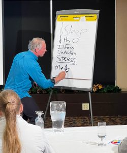 Dr. Duncan writing on a big notepad at a workshop in Olympia