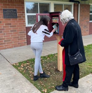 young girl and a woman at a Little Free Library at a North Thurston Elementary School