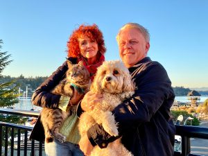 Fred and Debbie Paparelli holding their dog and cat on the boardwalk in Olympia