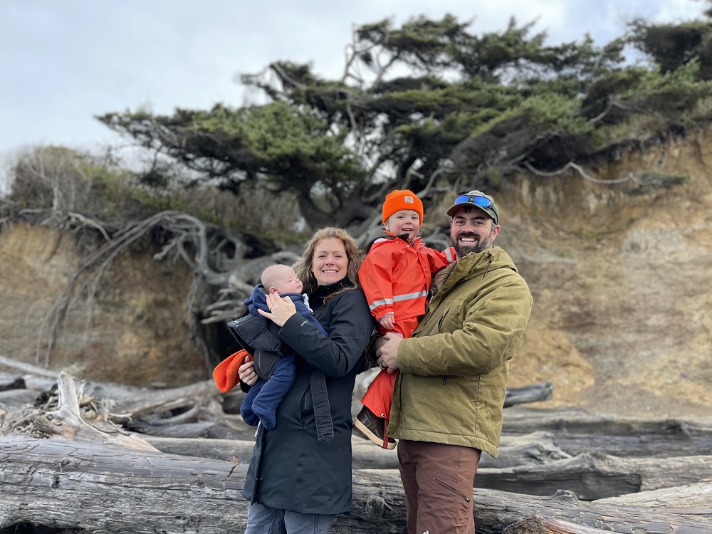 Jane and Lucas Shuler and their two kids standing by the Tree of LIfe in Kalaloch Campground