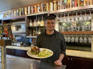 Chef Jackson Kramer serves a northwest elk burger, at Creekside Restaurant in the Olympic National Park