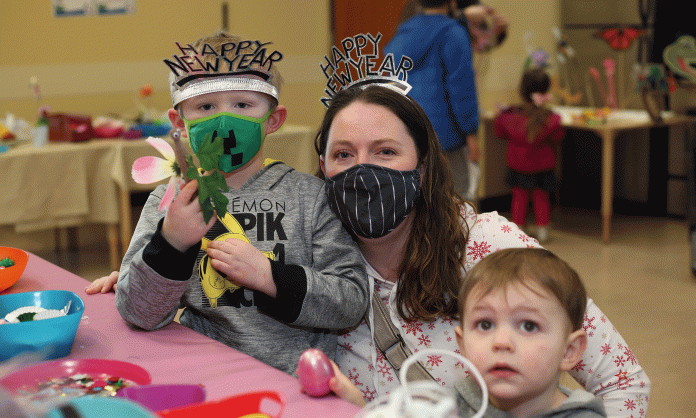 kids and a parent with New Year's party hats on and masks