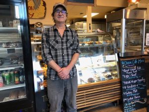 person standing in front of the glass display at Blue Heron Bakery