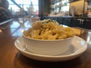 macaroni and cheese in a bowl on a brown table at Cynara