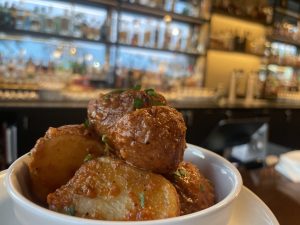 patatas bravas in a bowl on a table at Cynara