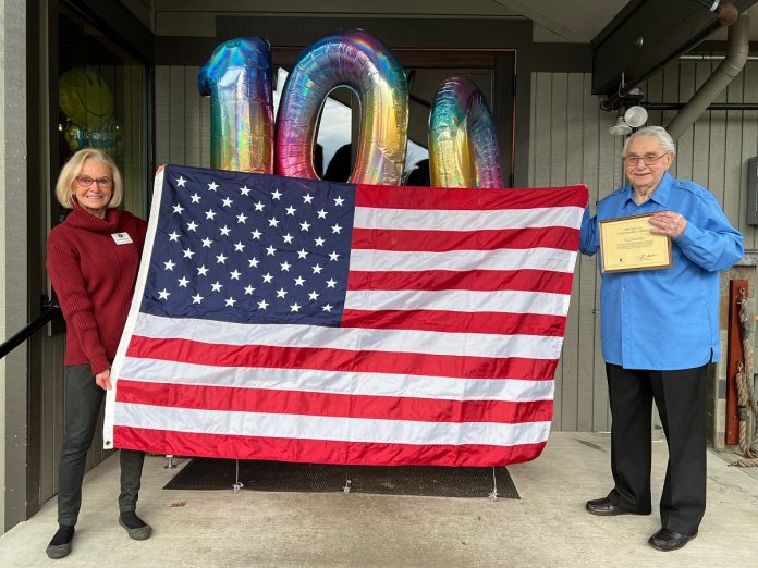 Karen Schoessel presents Harvey Drahos with the US Flag flown in his name at the U.S. Capitol.