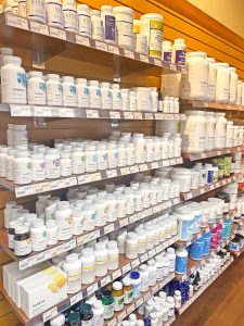 rows of white supplement bottles on glass shelves at NW Remedies in Olympia