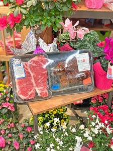 packaged steak sitting among flowers 